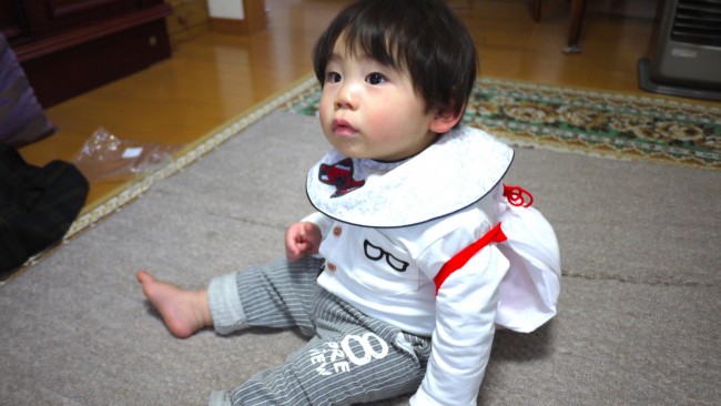 1.8kgのお餅を背負っても泣かずにきょとんとしていた息子。家族全員がスマホをかまえて撮影し、盛り上がった瞬間